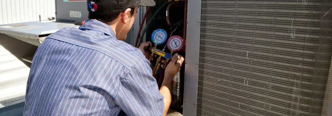 HVAC technician servicing a condenser unit in Hopewell
