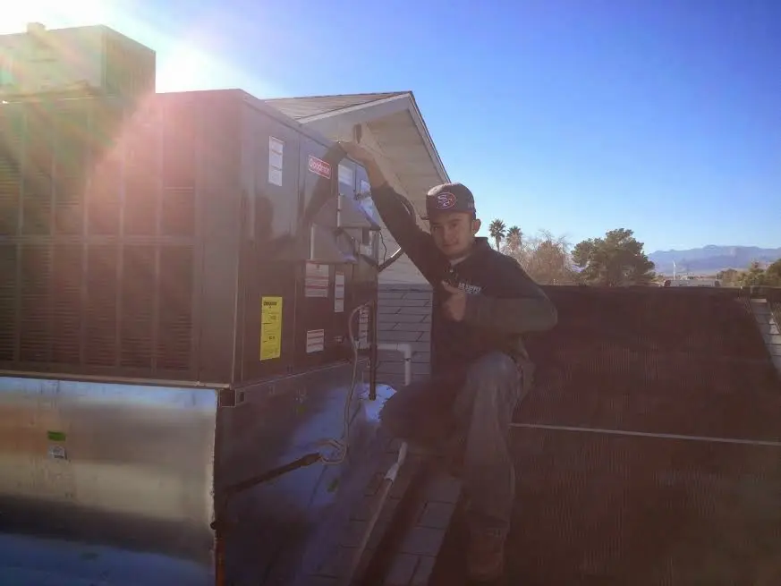 HVAC technician performing Heat Pump Repair on a rooftop unit in Hopewell